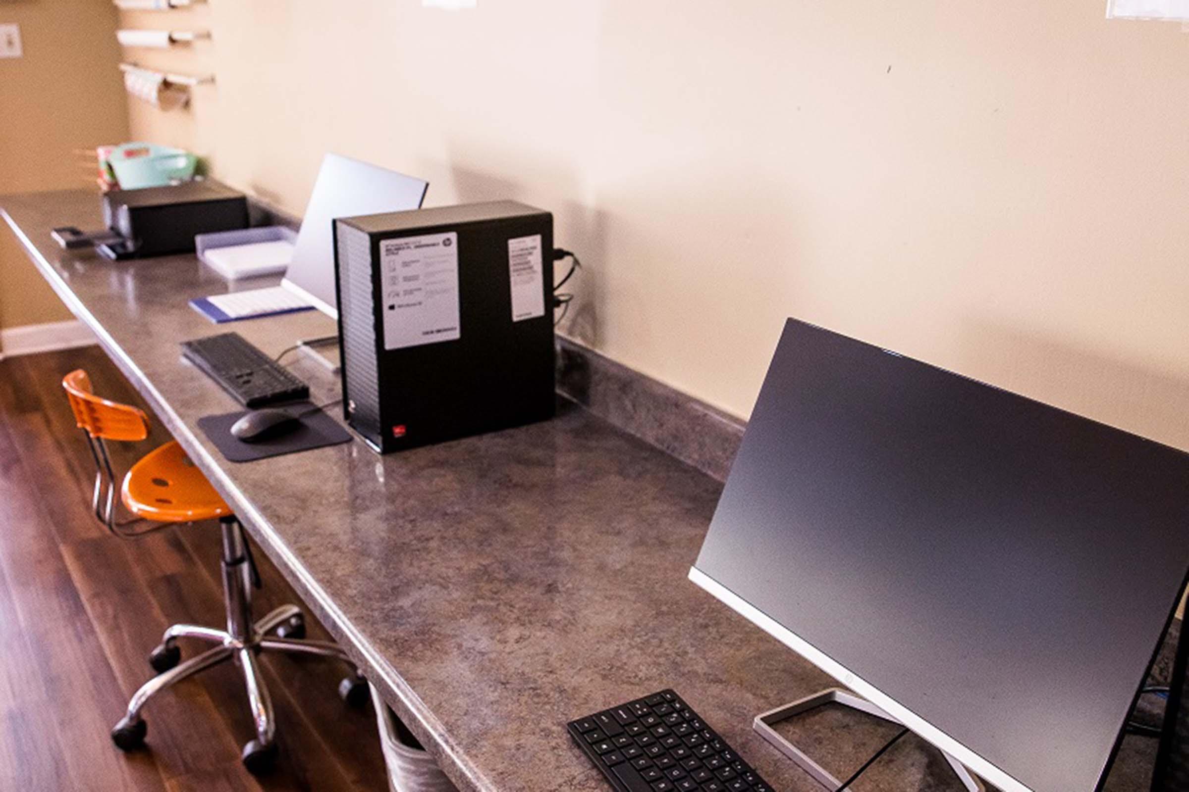 a desk with a laptop computer sitting on top of a wooden table