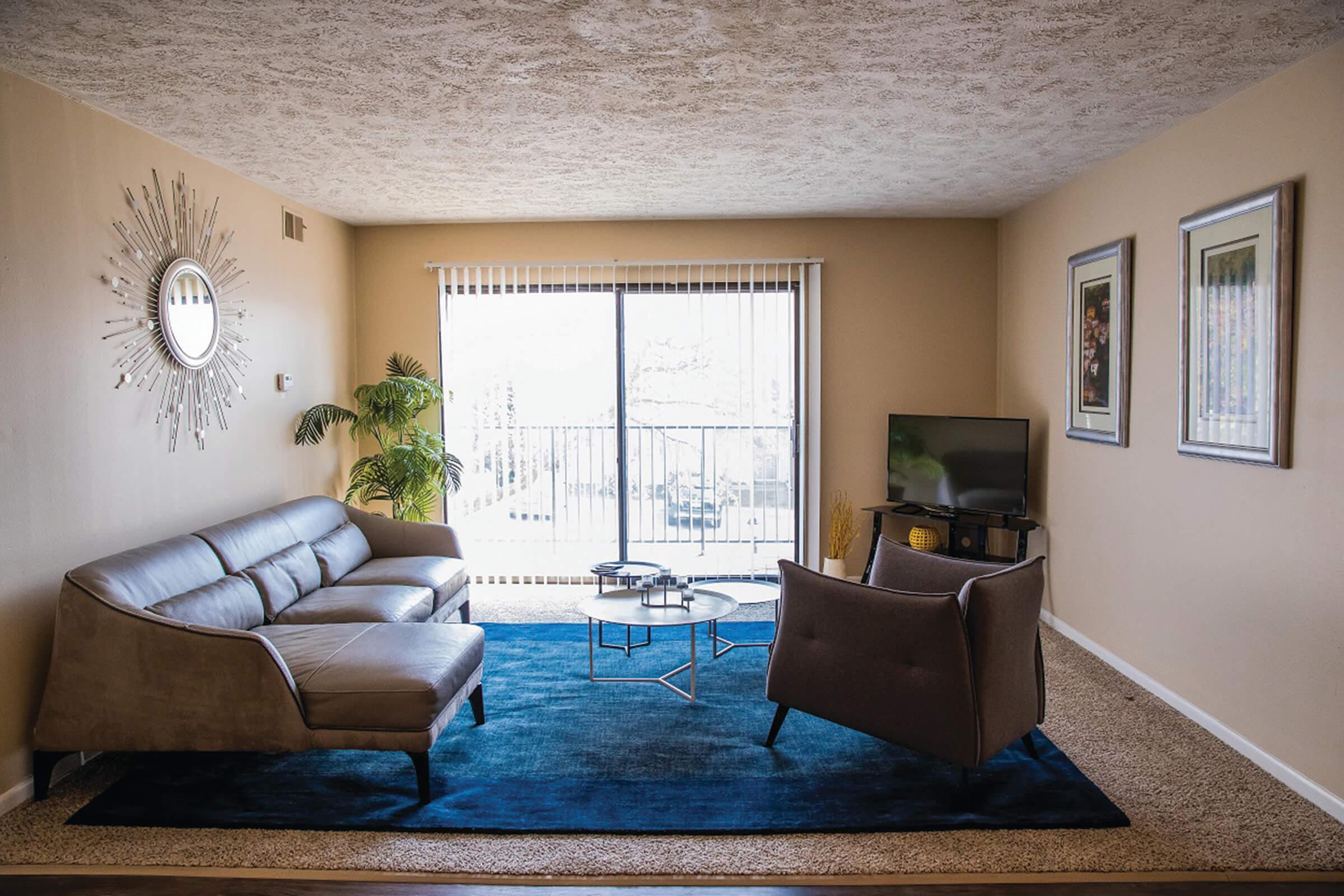 a living room filled with furniture and a large window