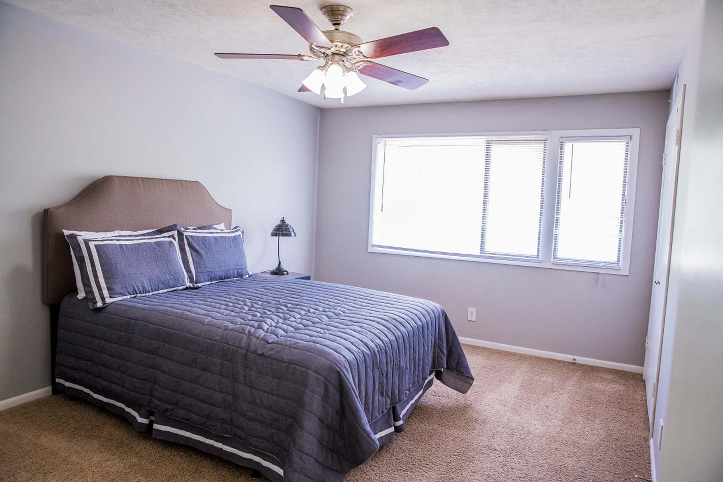 a bedroom with a bed and desk in a small room