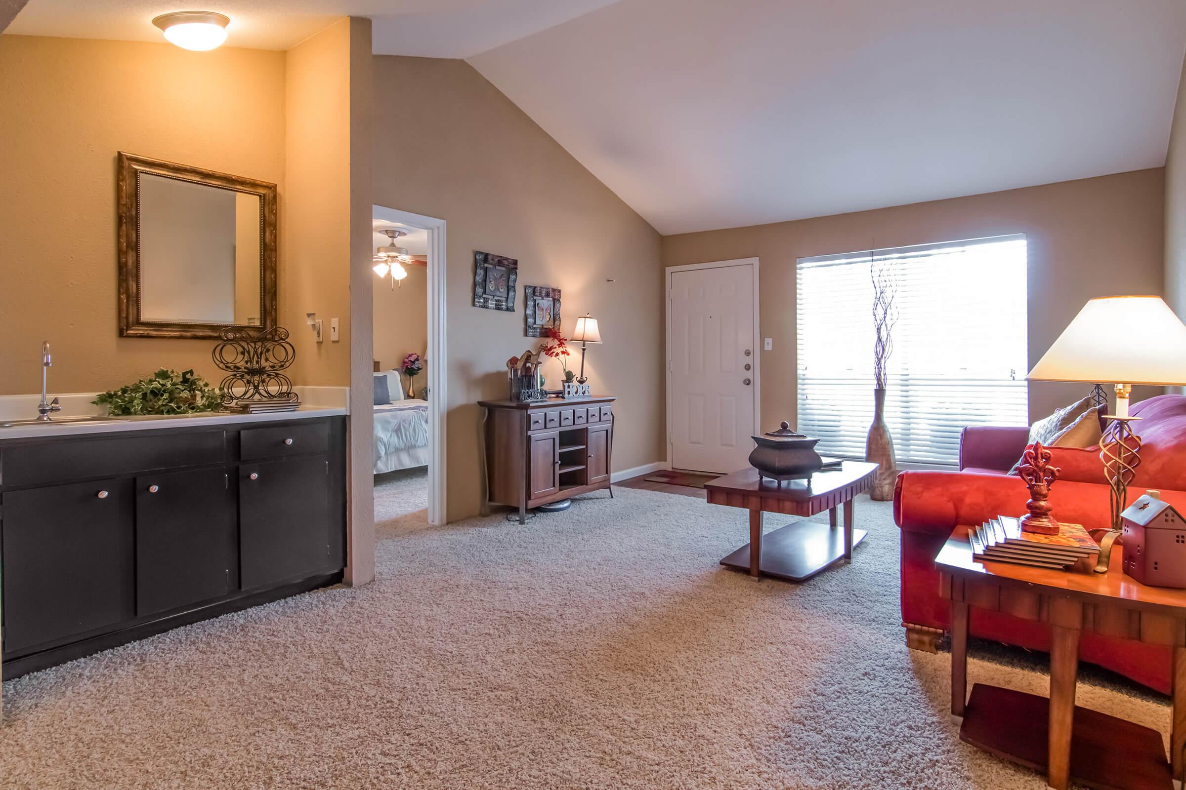 a living room filled with furniture and a large mirror