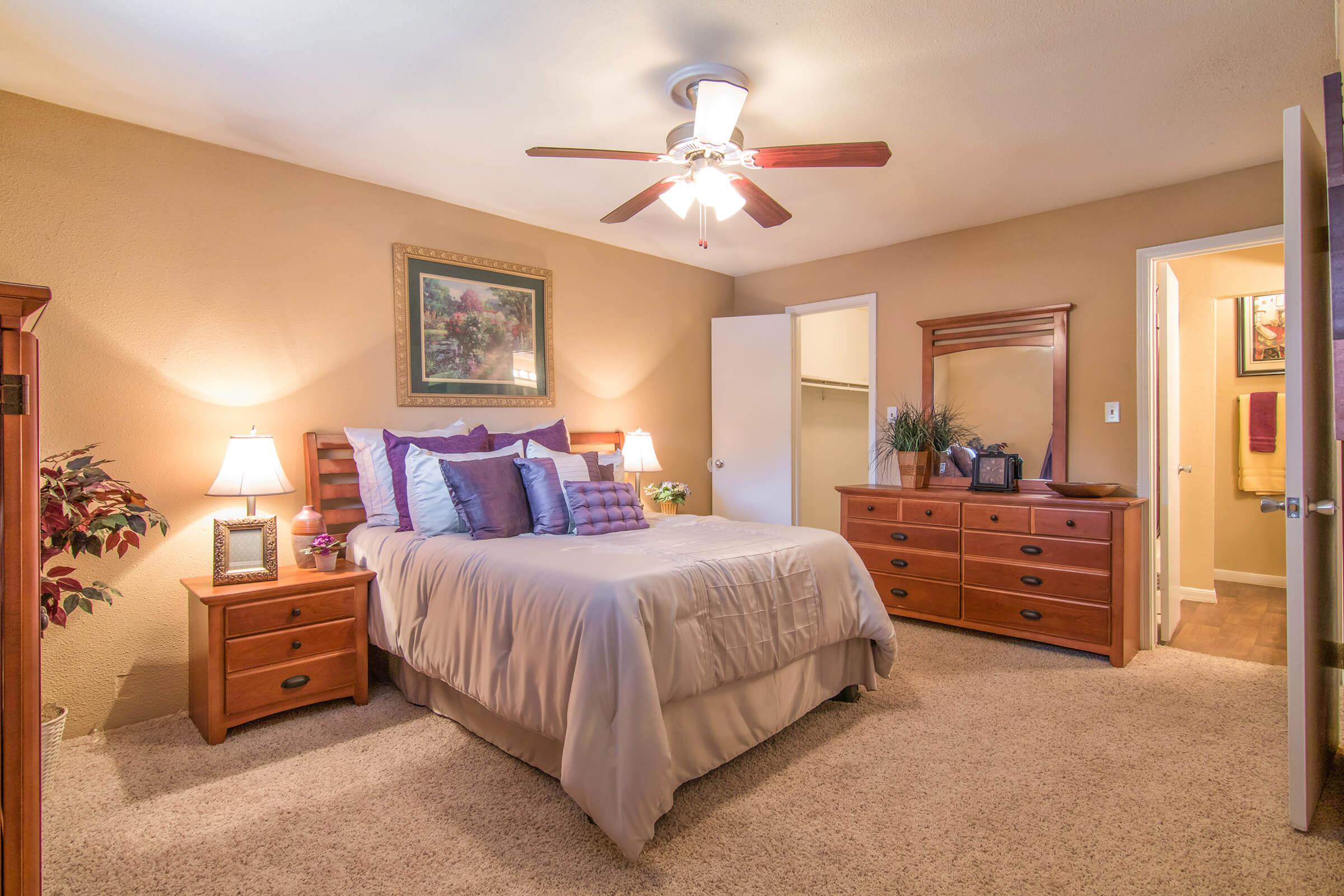 a bedroom with a bed and desk in a room