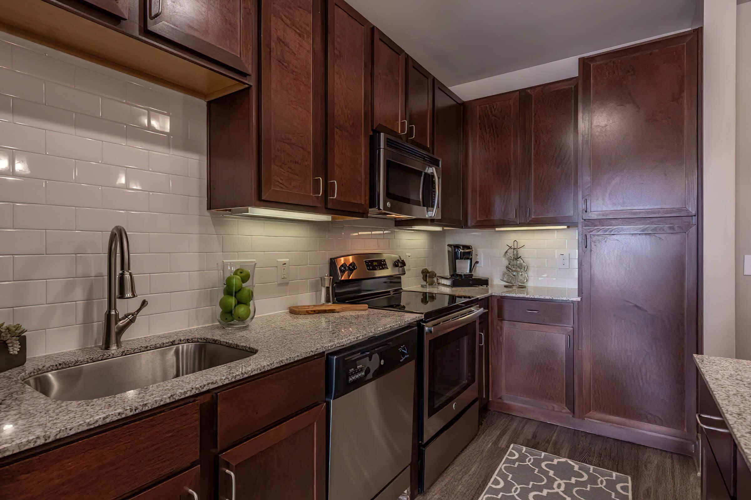 a modern kitchen with stainless steel appliances and wooden cabinets