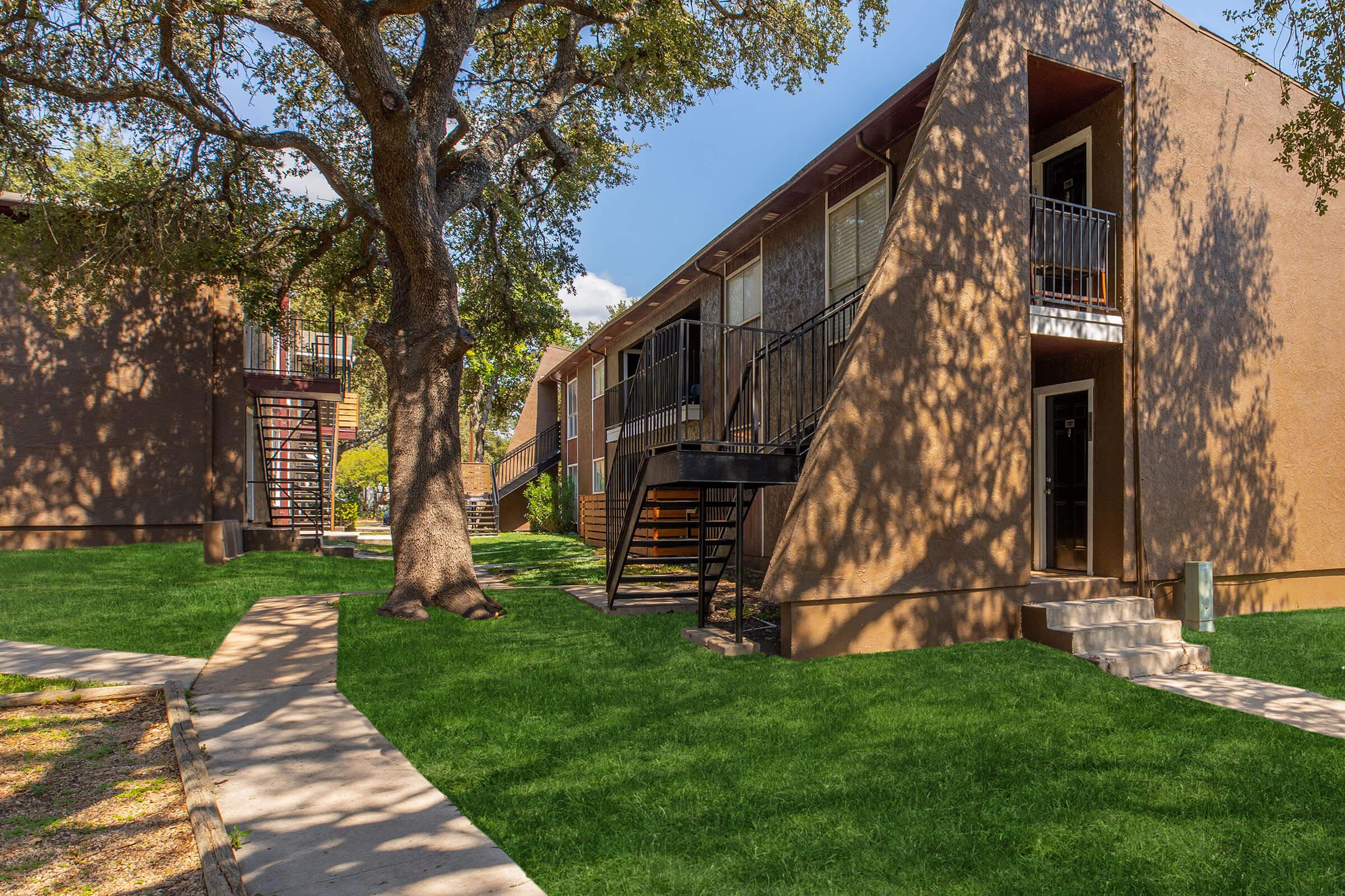 a large lawn in front of a brick building