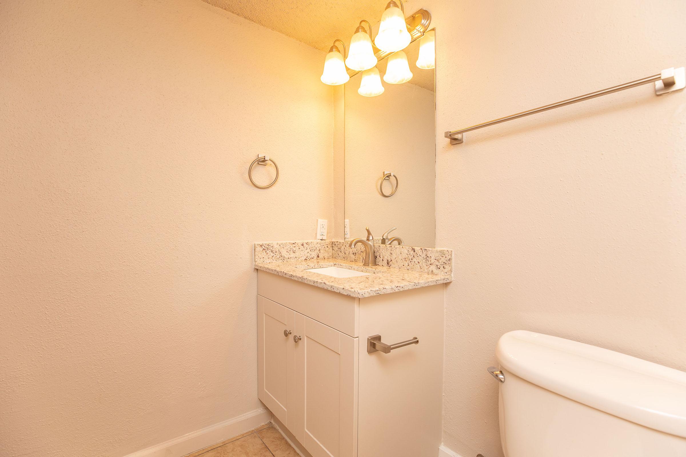 a sink sitting under a mirror