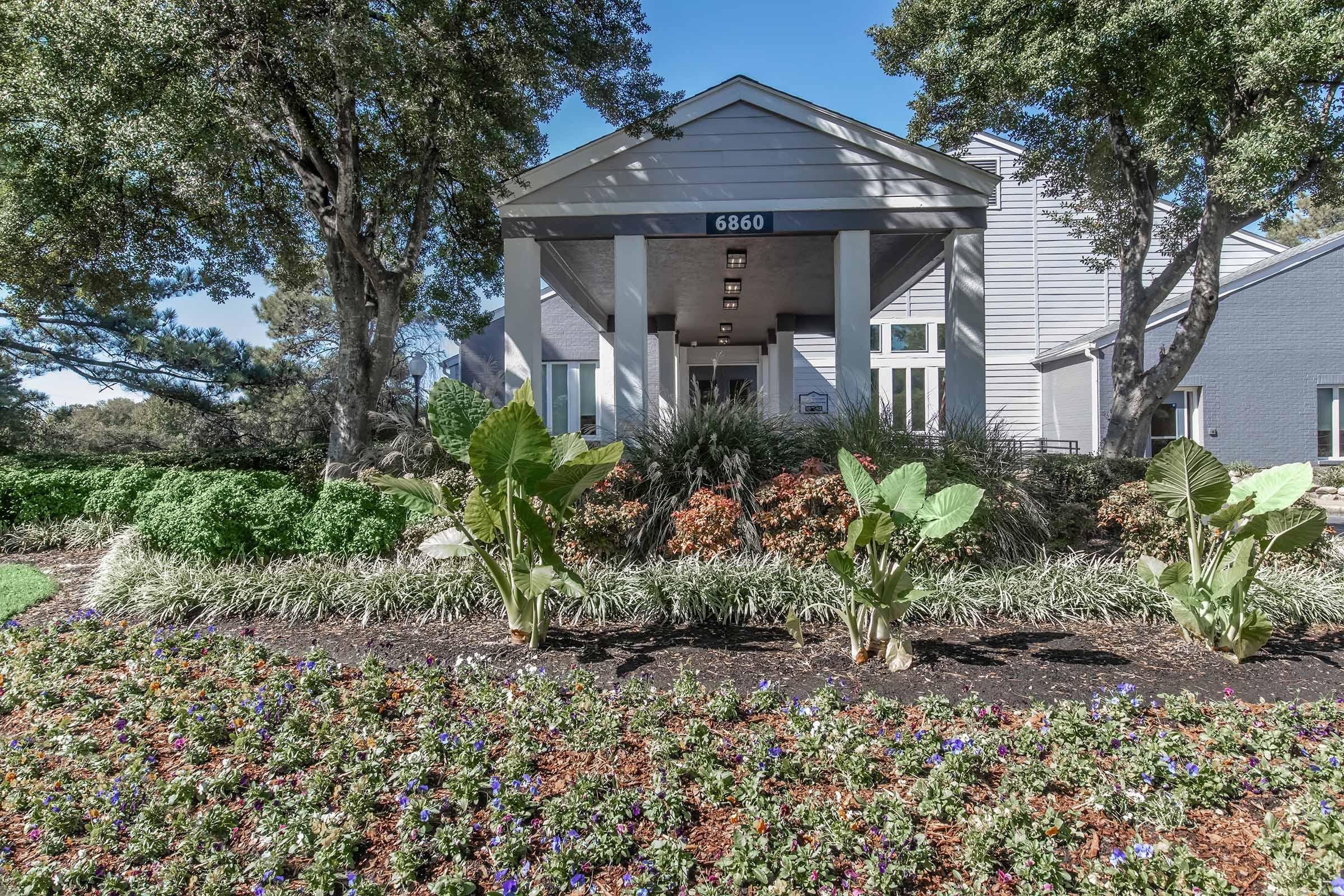 a close up of a flower garden in front of a house