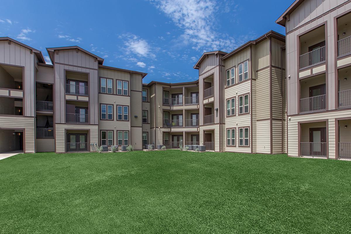 a large lawn in front of a brick building