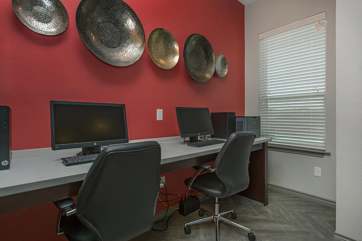 a desk with a computer and a chair in a room