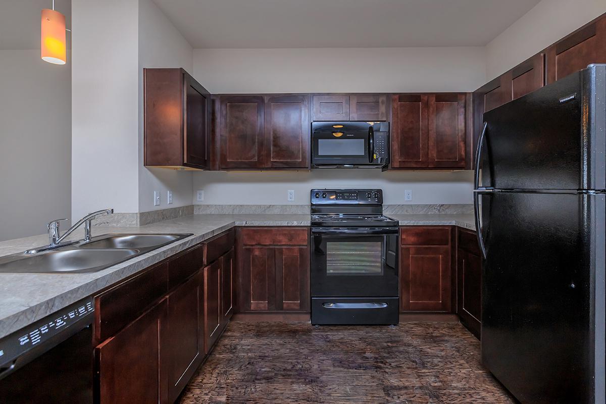 a modern kitchen with stainless steel appliances and wooden cabinets