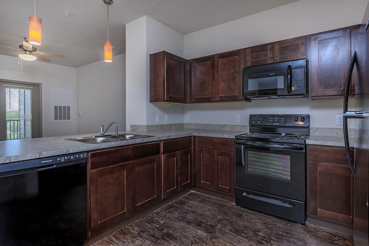 a modern kitchen with stainless steel appliances and wooden cabinets