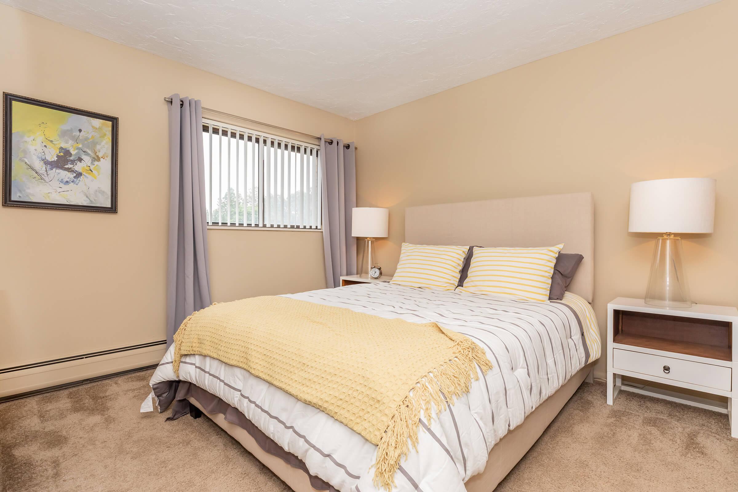 a bedroom with a bed and desk in a hotel room