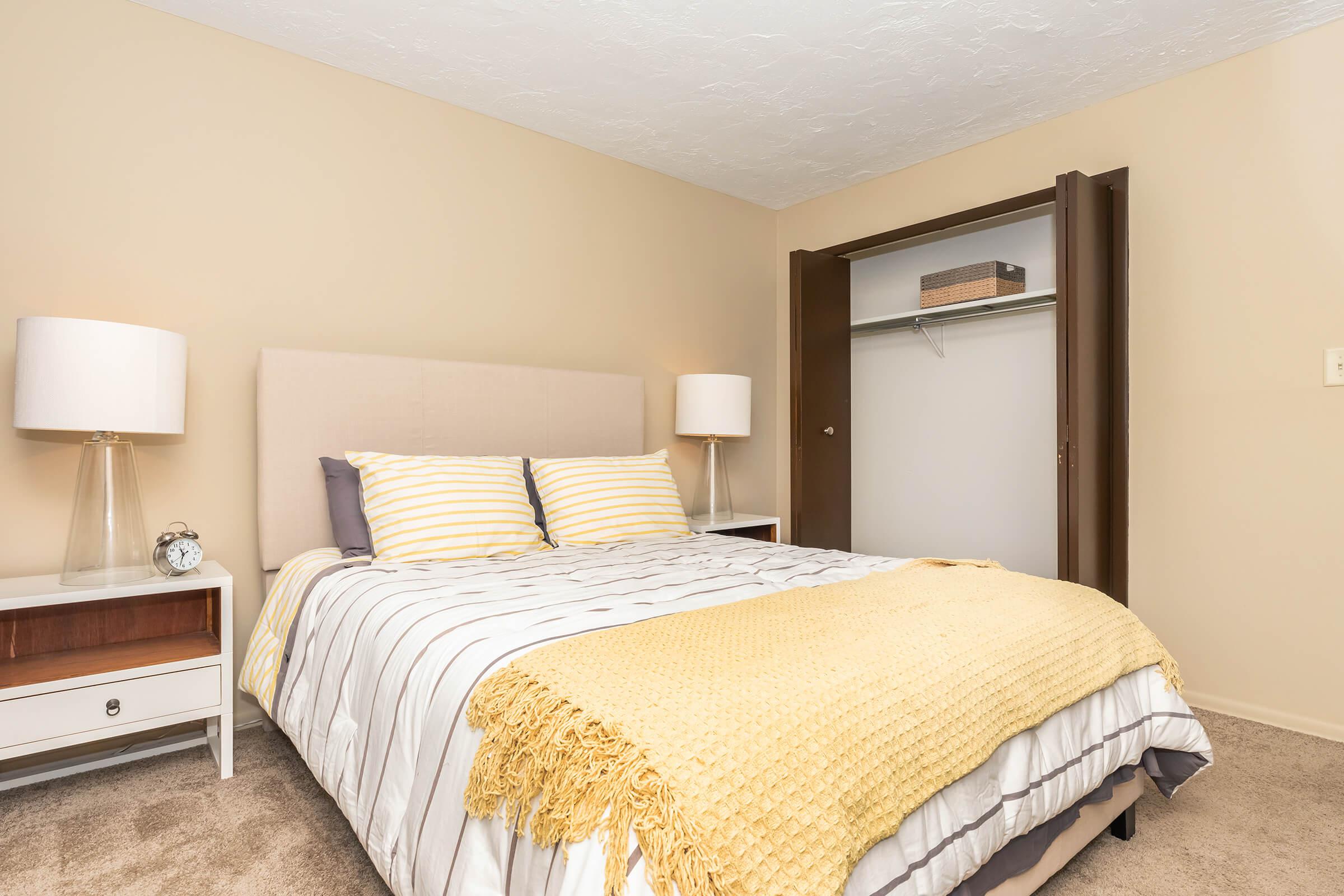 a bedroom with a bed and desk in a hotel room