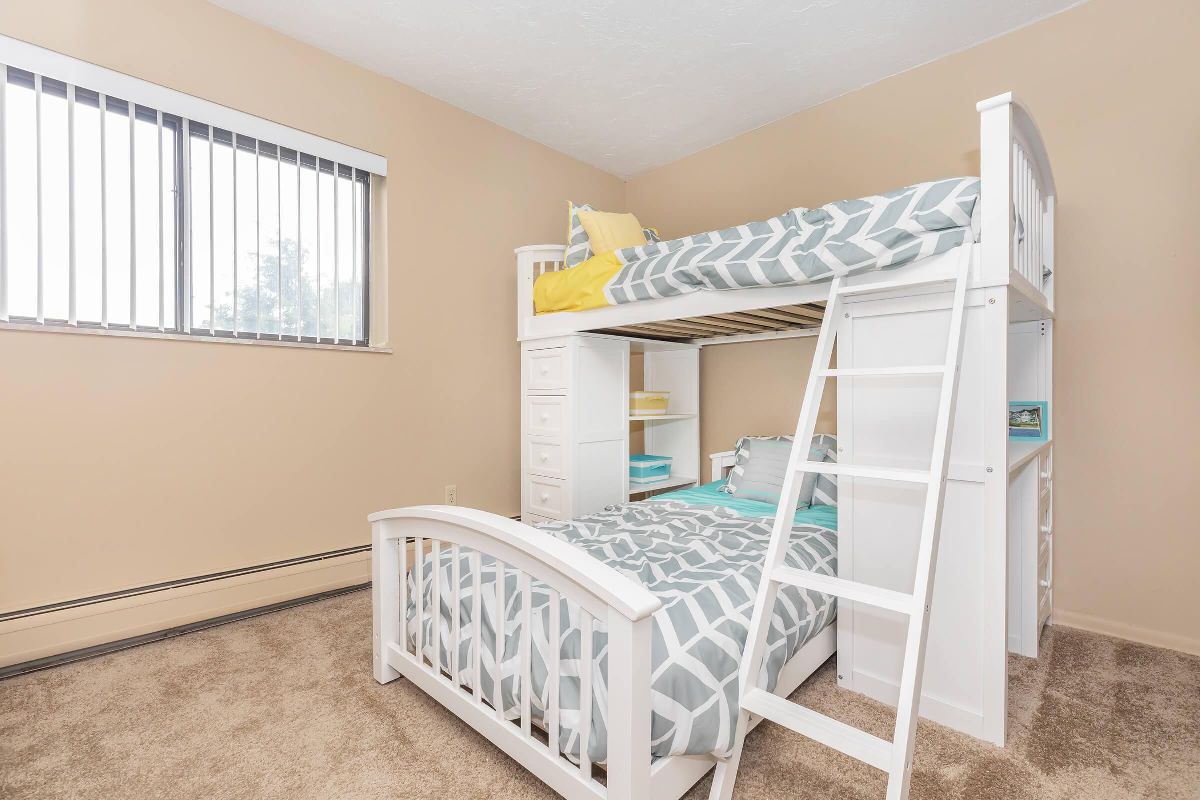 a bedroom with a bed and a chair in a room