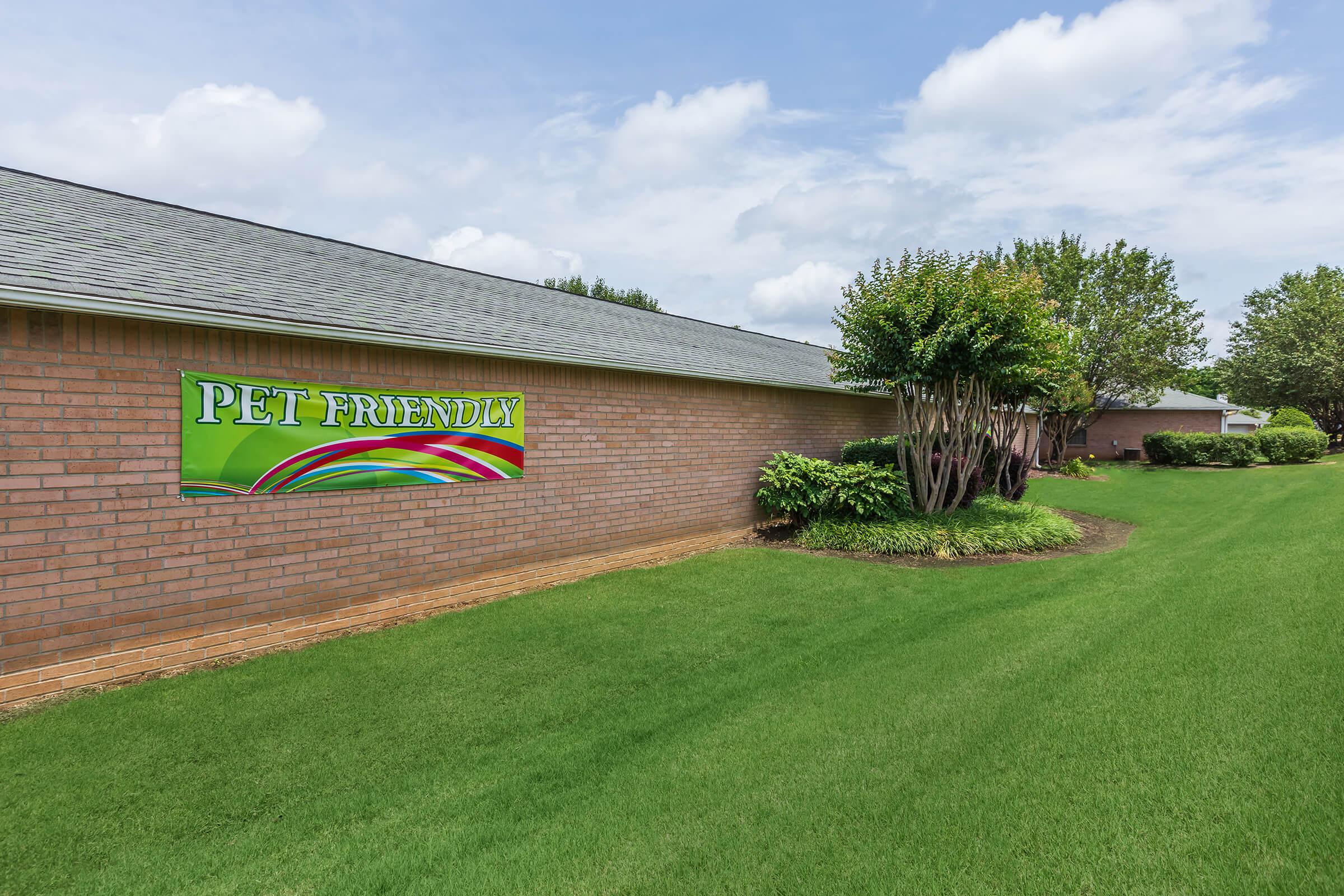 a large brick building with green grass in front of a house