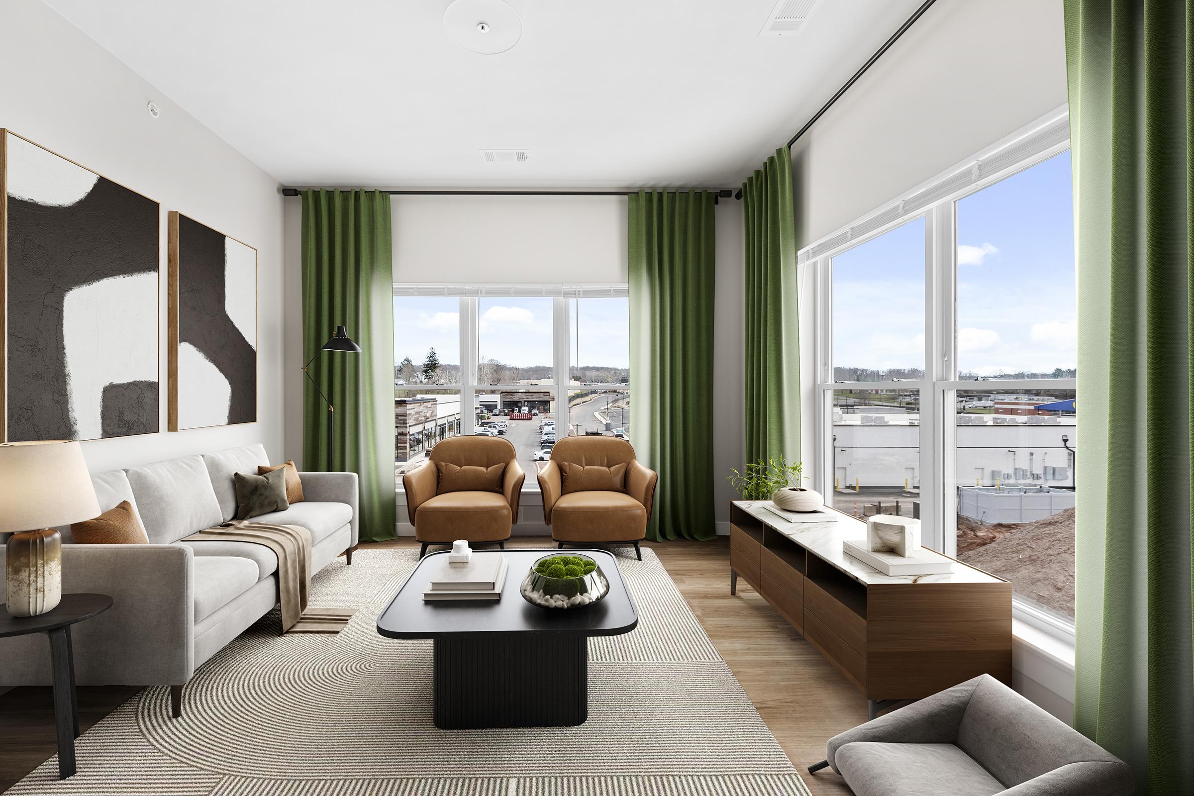 A modern living room featuring a gray sofa, two tan armchairs, and a coffee table. Large windows with green curtains provide natural light and a view of the outside. The décor includes abstract wall art, a patterned area rug, and plants for a fresh touch. The space is stylish and inviting.