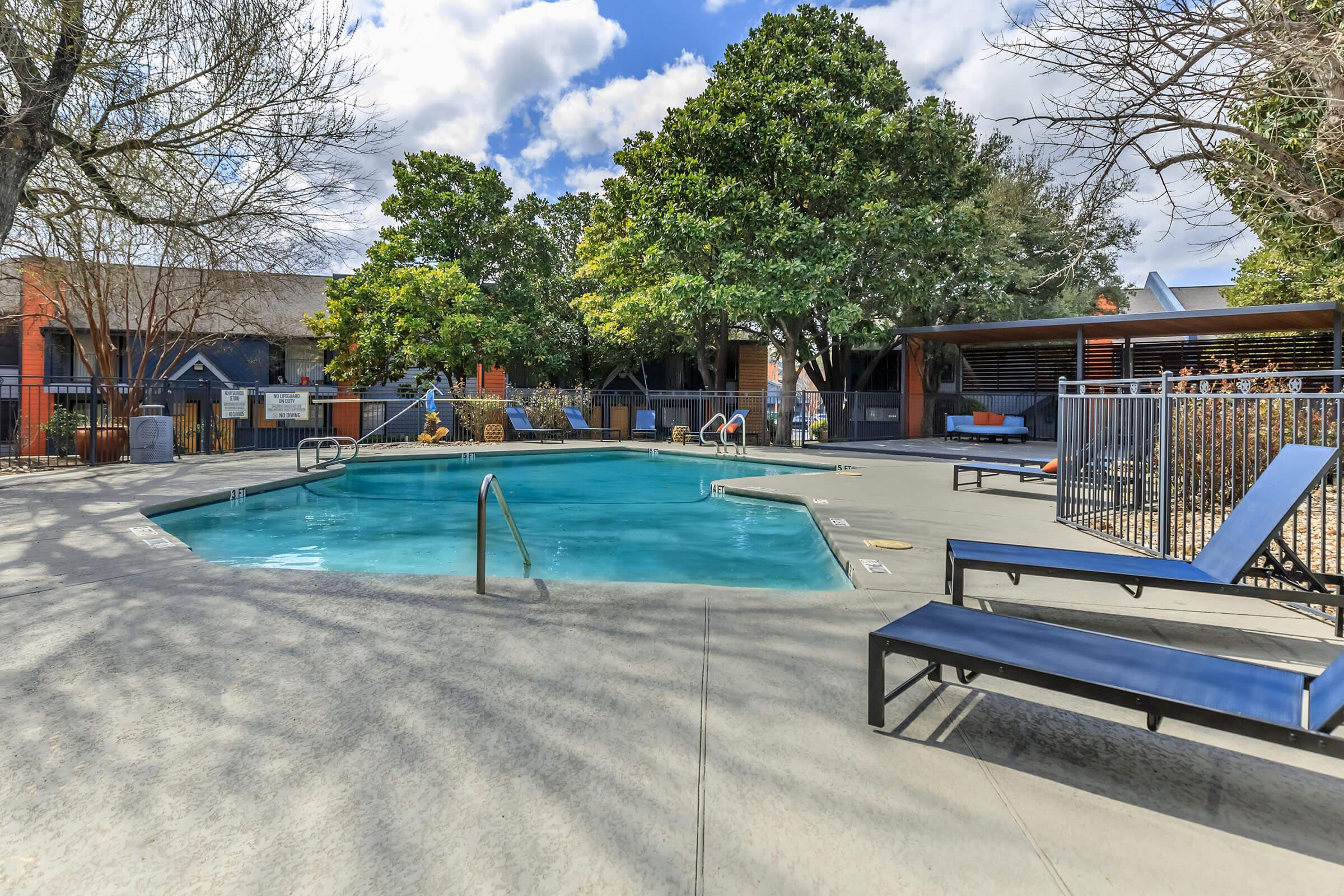 an empty park bench next to a pool