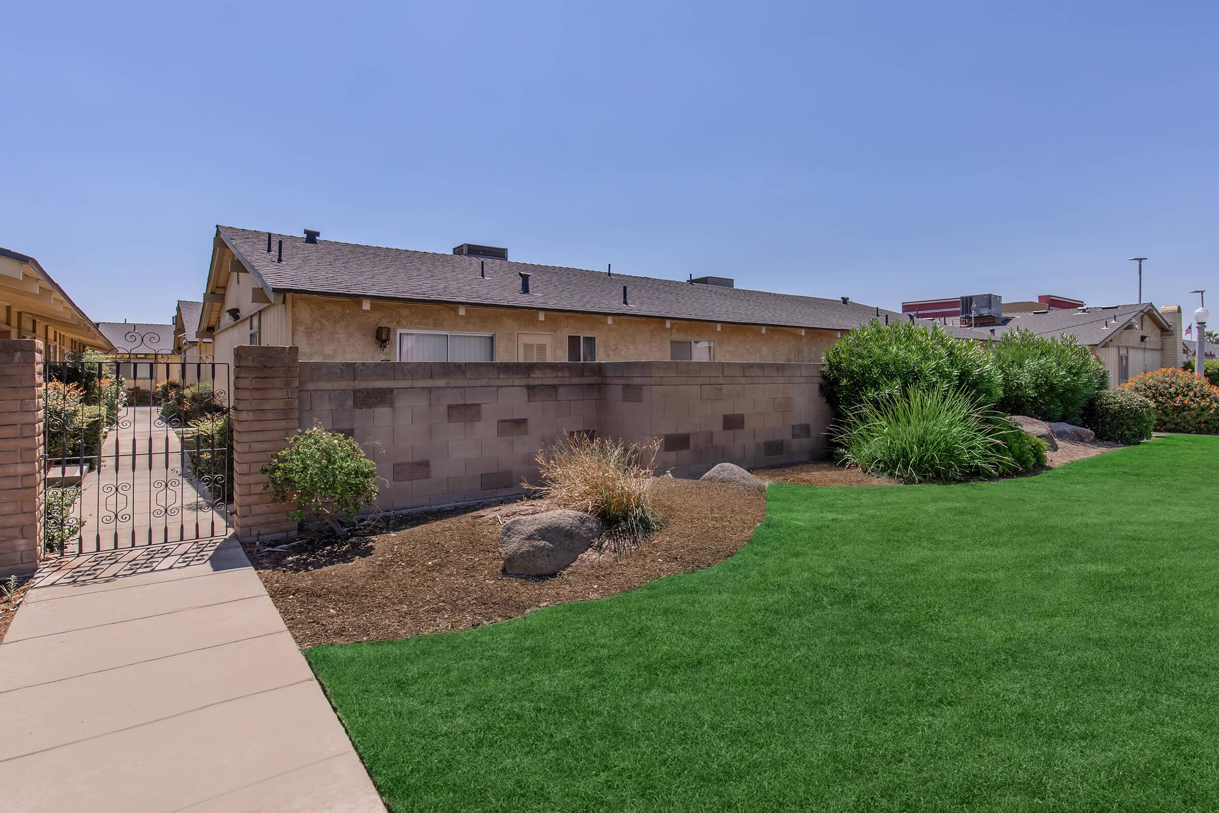 a large brick building with green grass