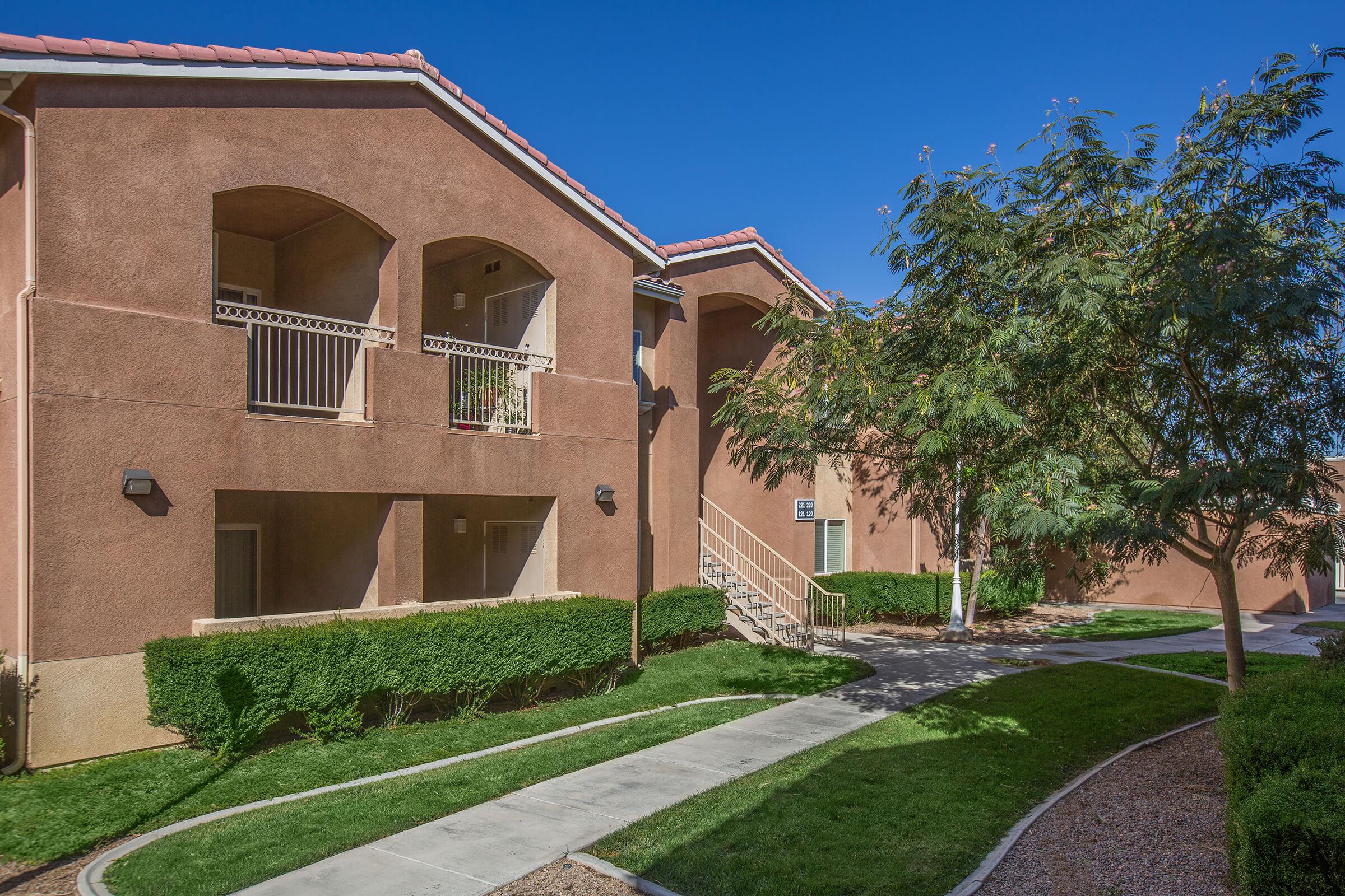 a large brick building with grass in front of a house