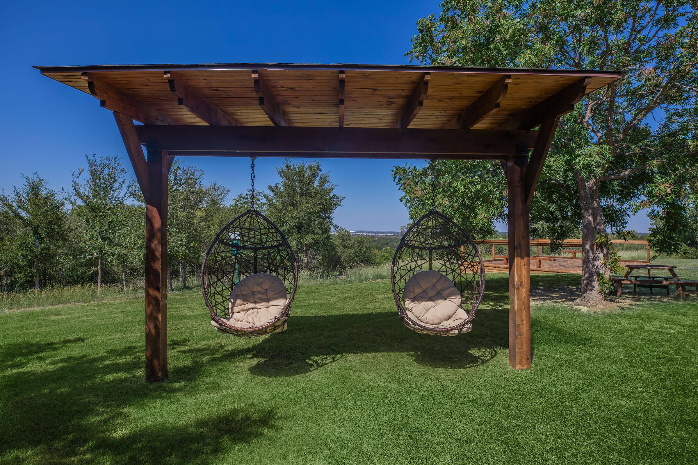 a group of lawn chairs sitting on top of a lush green field