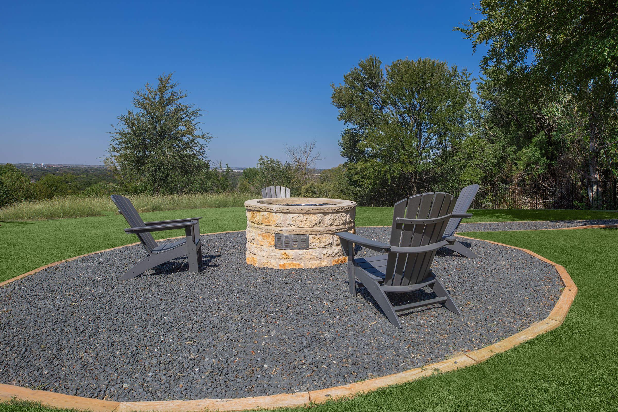 a couple of lawn chairs sitting on top of a grass covered field