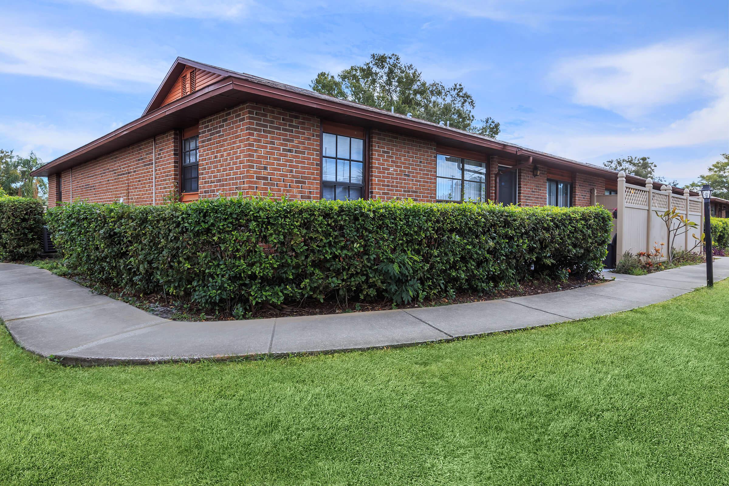 a large brick building with green grass in front of a house