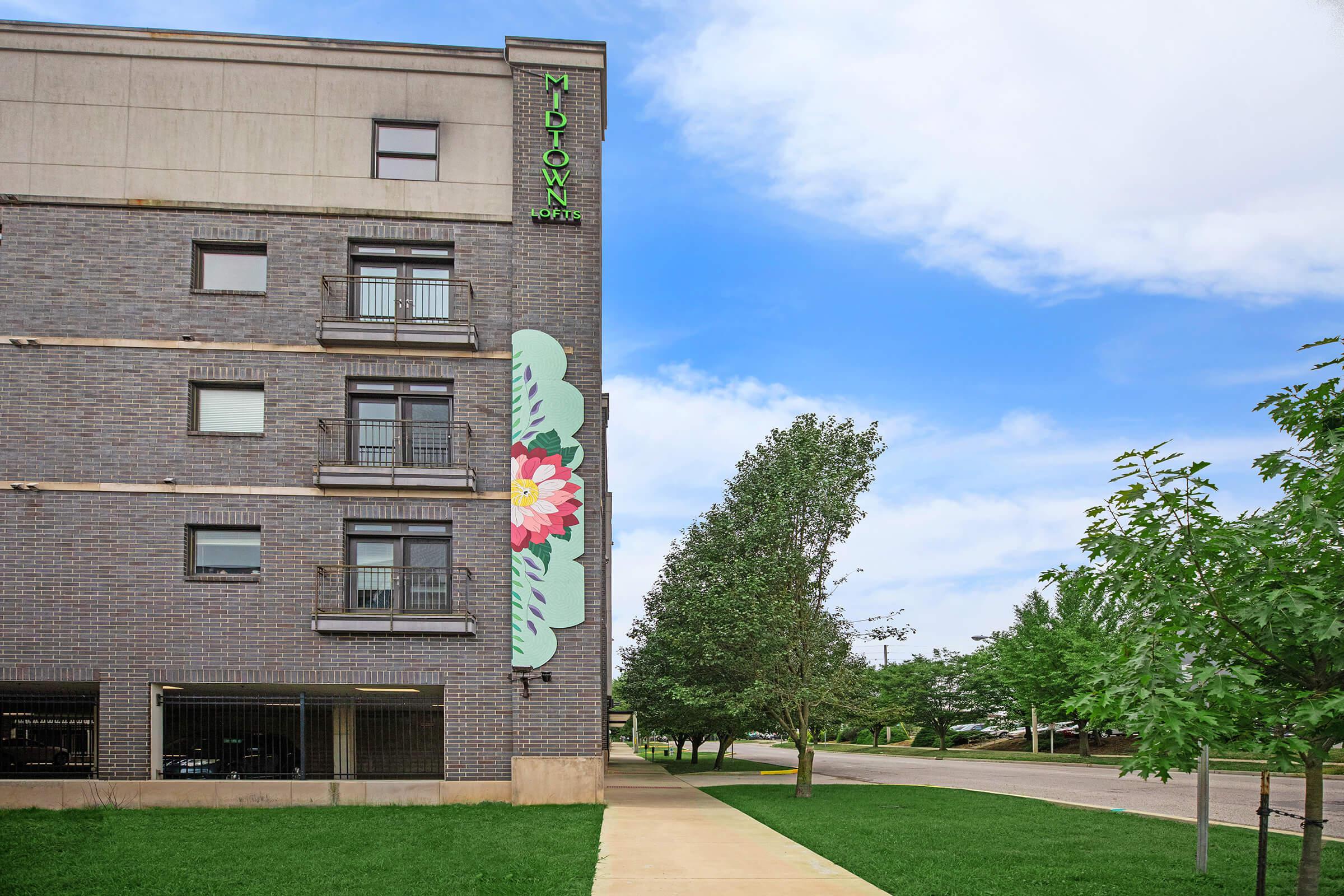 a large brick building with grass and trees