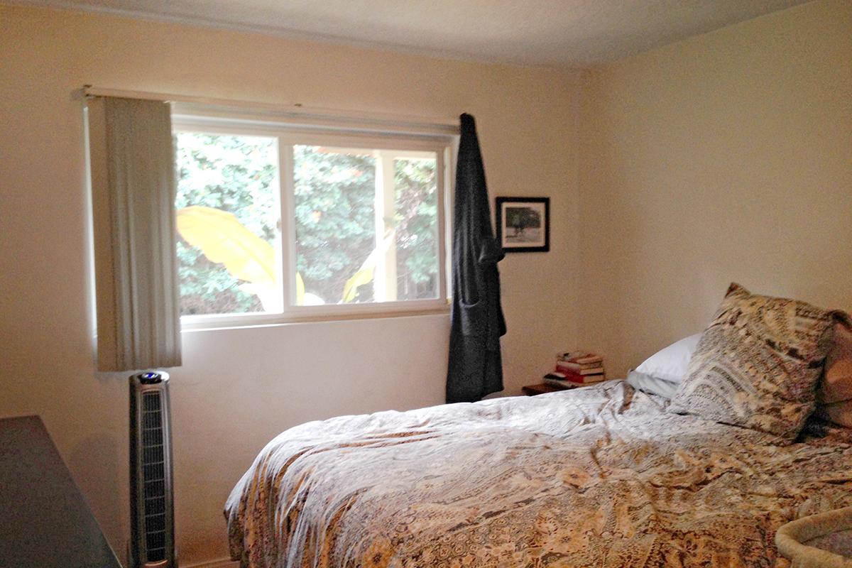 a bedroom with a large bed sitting next to a window