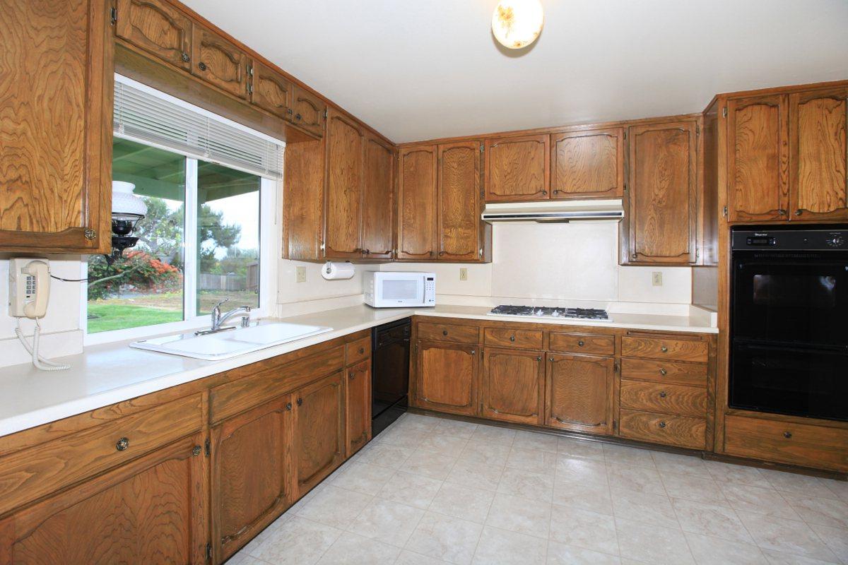 a large kitchen with stainless steel appliances and wooden cabinets
