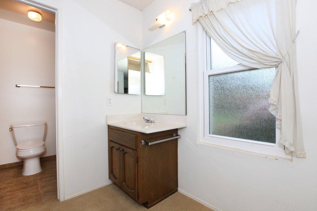 a white sink sitting under a window