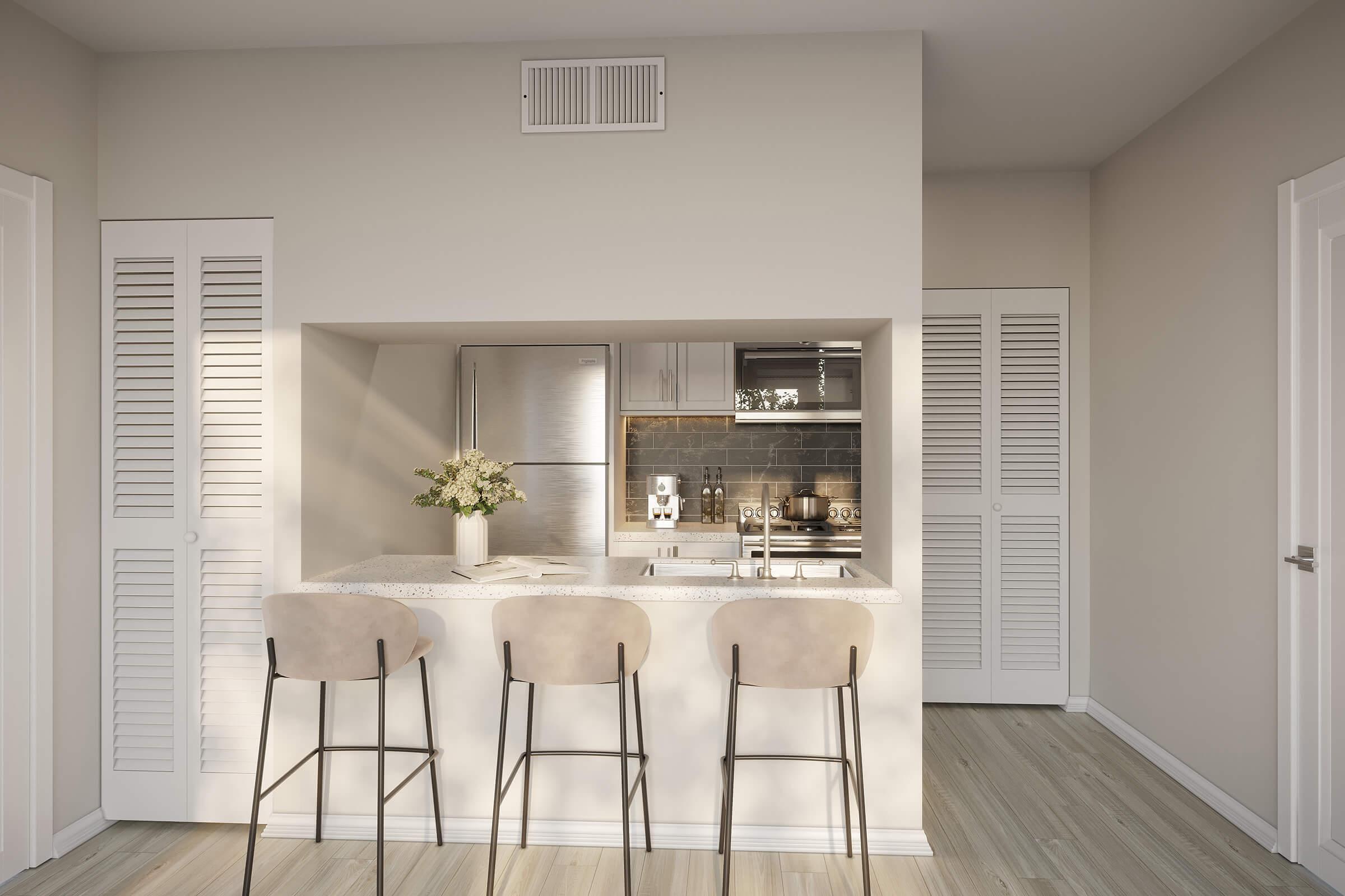 Modern kitchen featuring a light color palette with beige walls, a small breakfast bar with three tall stools, and a well-equipped kitchen area including stainless steel appliances. There is natural light coming in, enhancing the inviting atmosphere. The design is sleek and minimalistic.