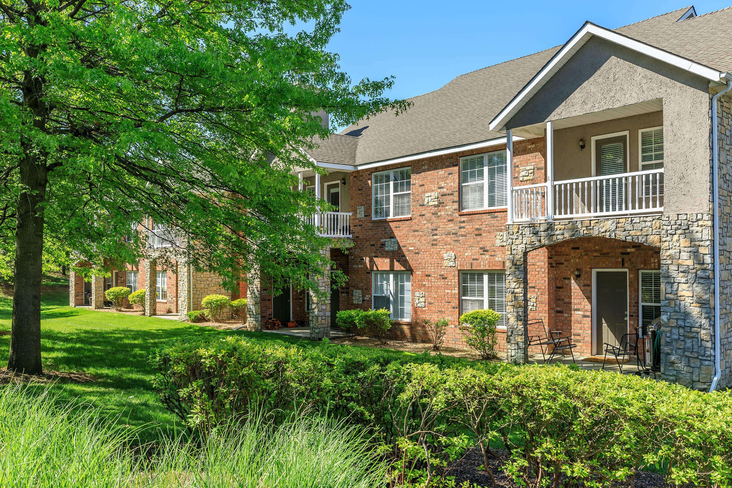 a large brick building with grass in front of a house