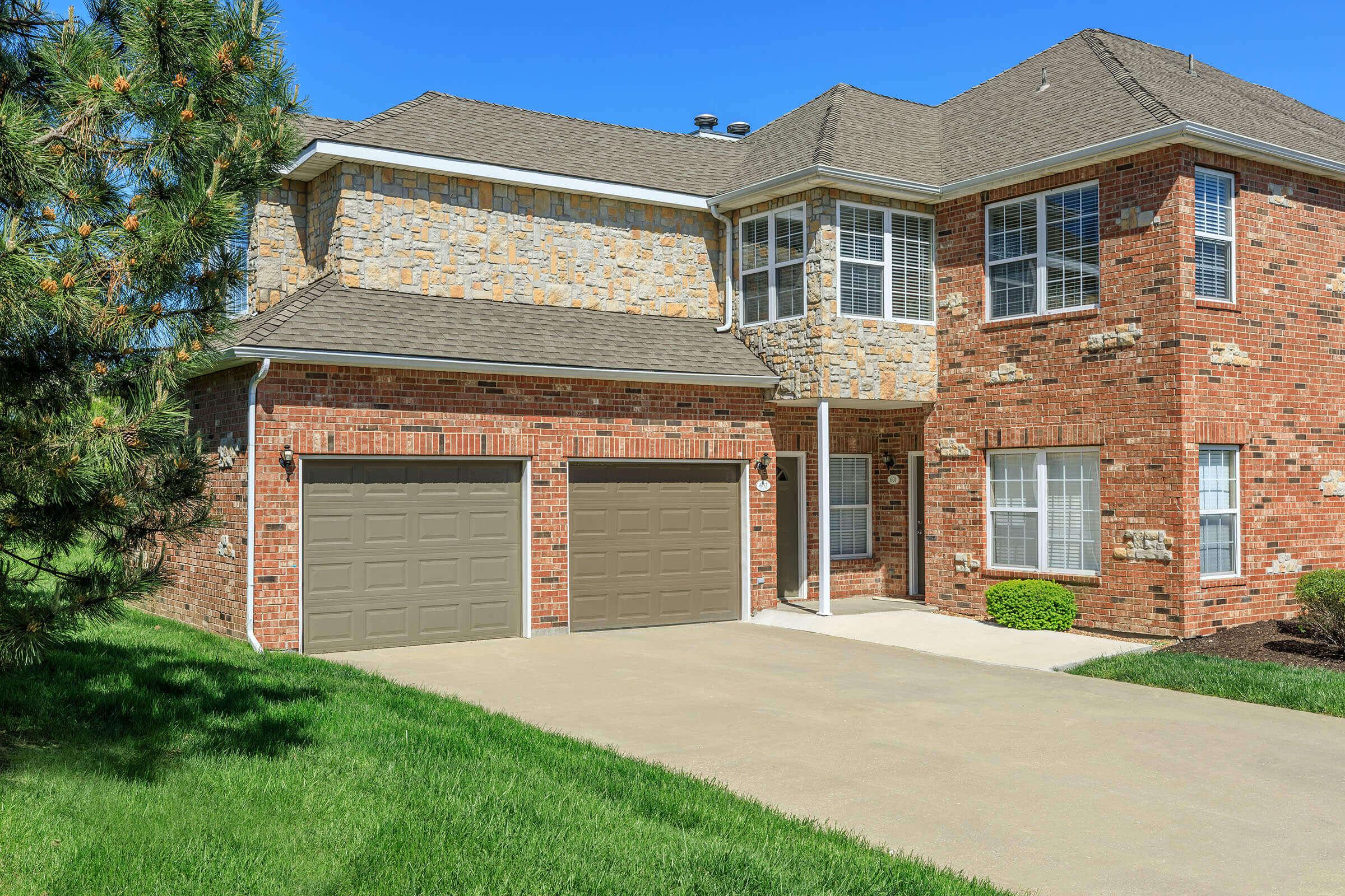 a large brick building with grass in front of a house