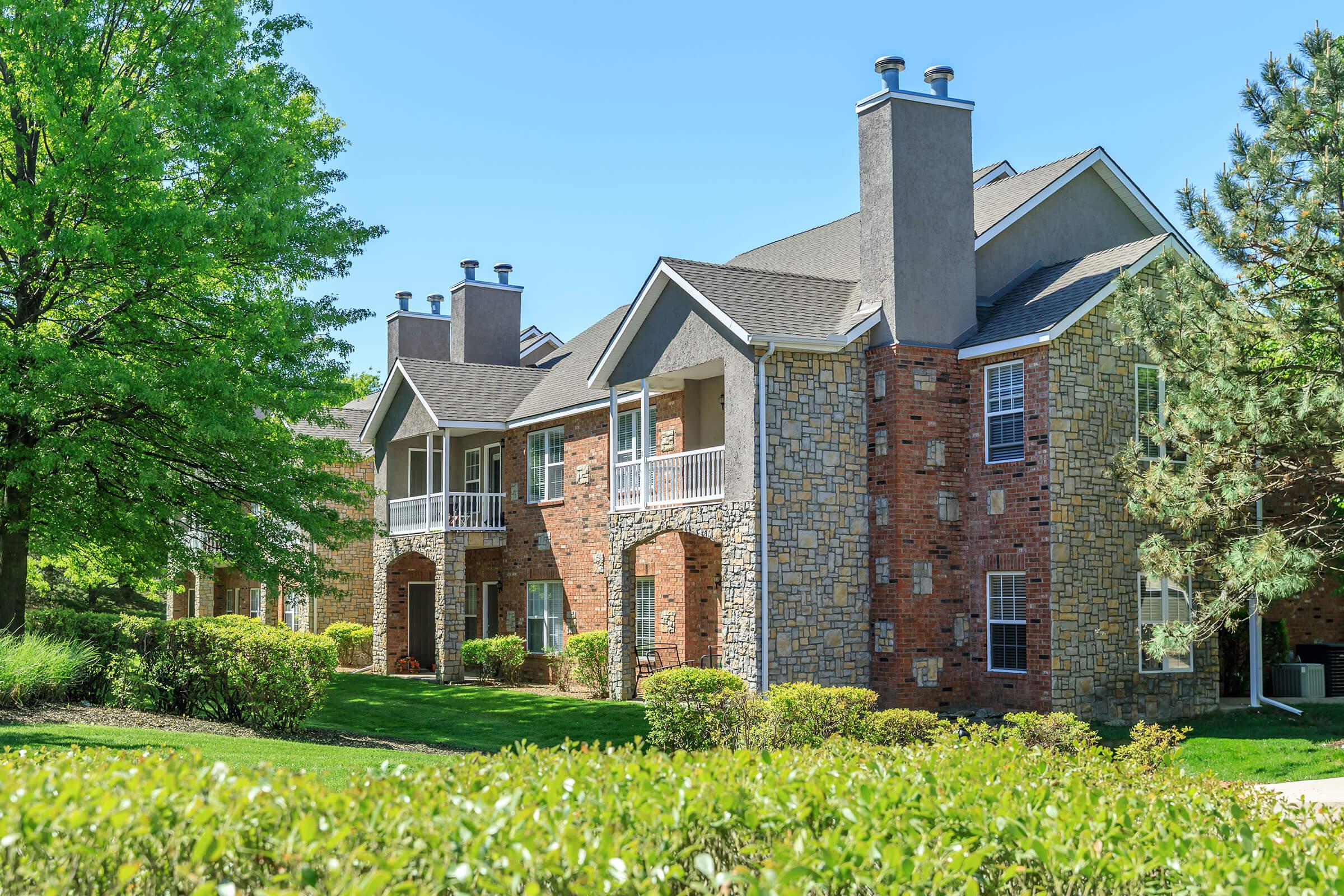 a large brick building with grass in front of a house