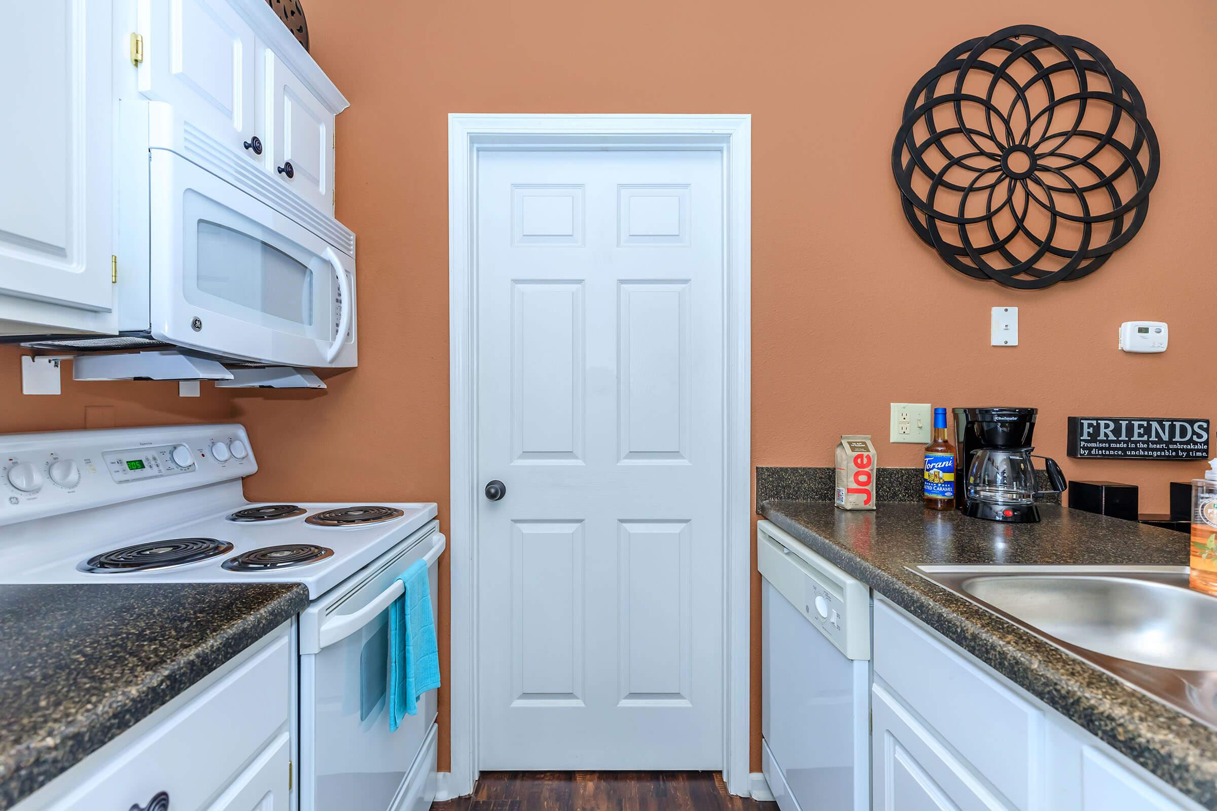 a kitchen with a stove a sink and a microwave