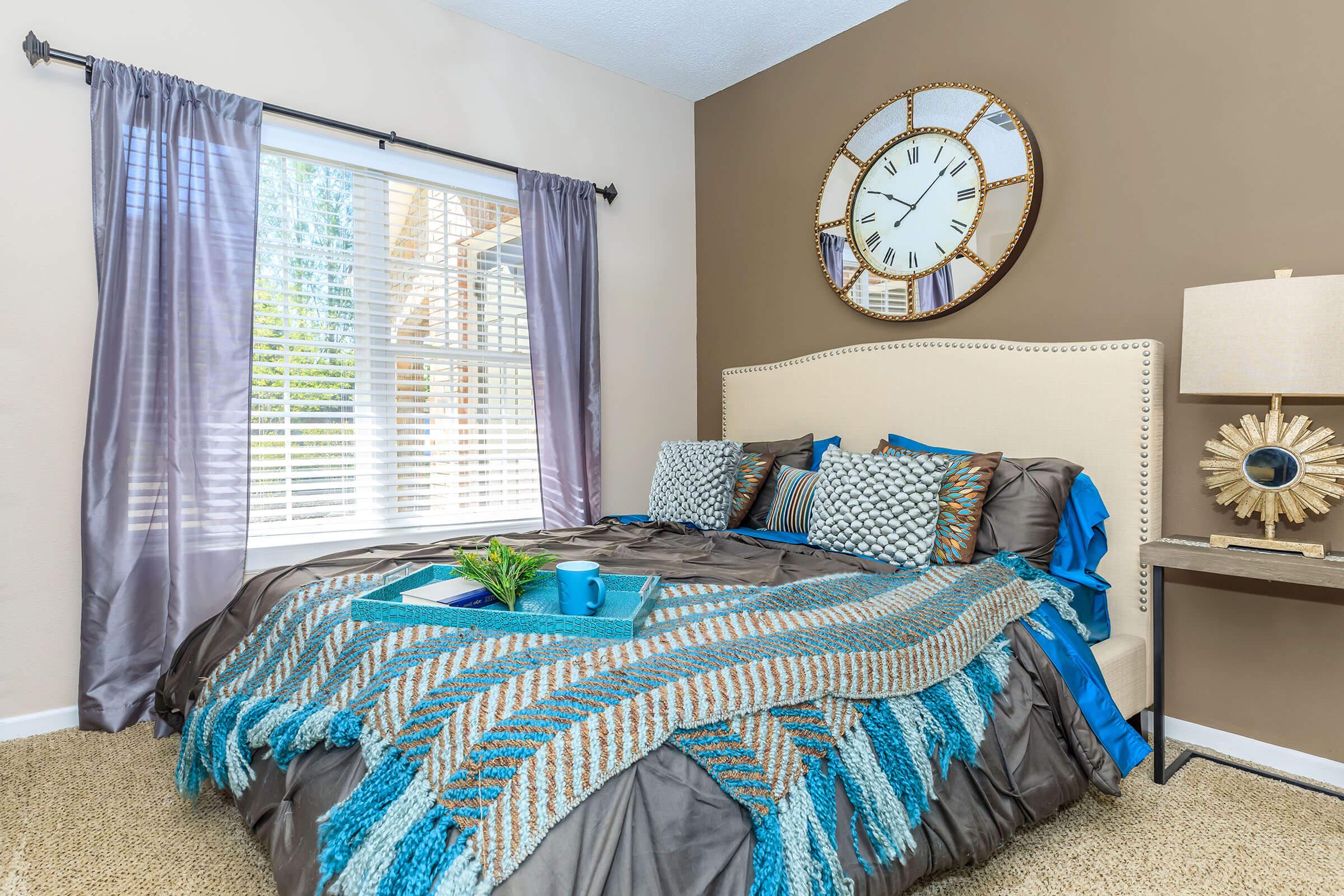 a bedroom with a clock at the top of a bed