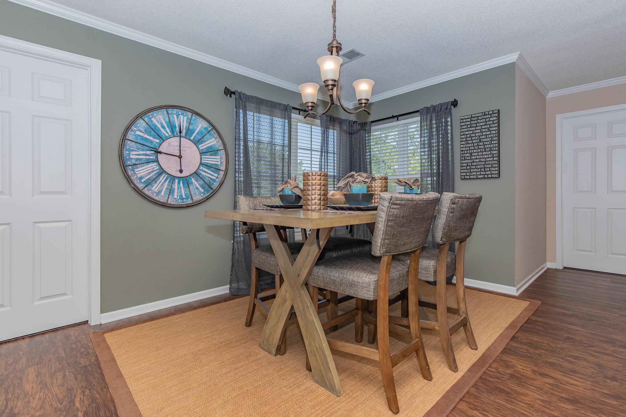 a living room with a clock at the top of a wooden floor