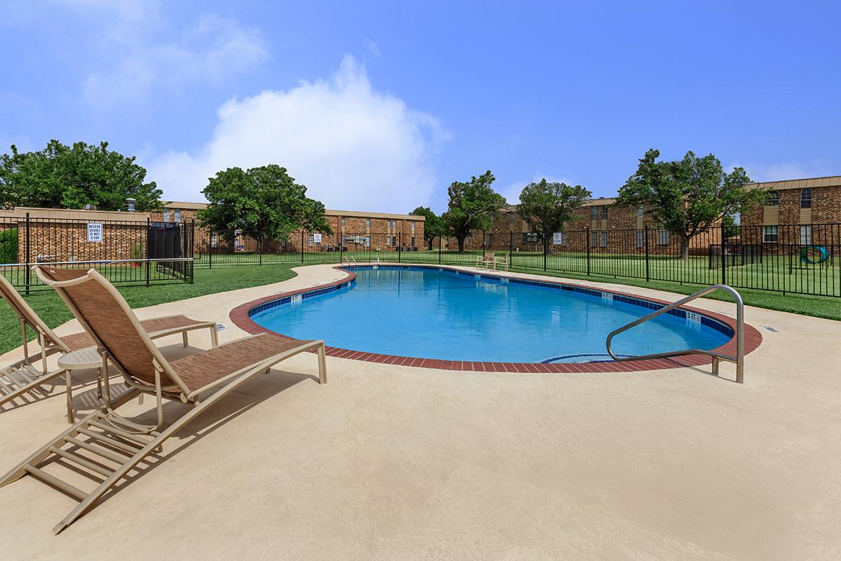 a group of lawn chairs sitting next to a pool of water