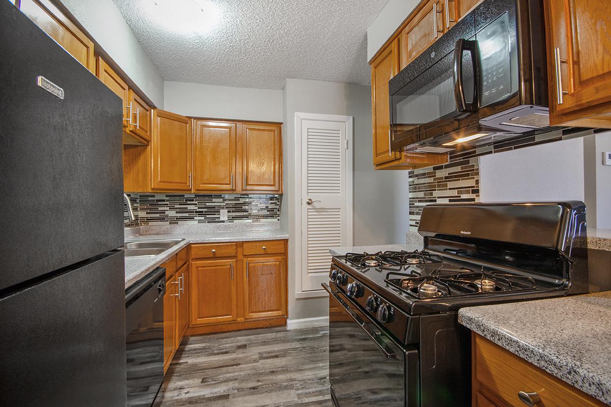 a modern kitchen with stainless steel appliances and wooden cabinets