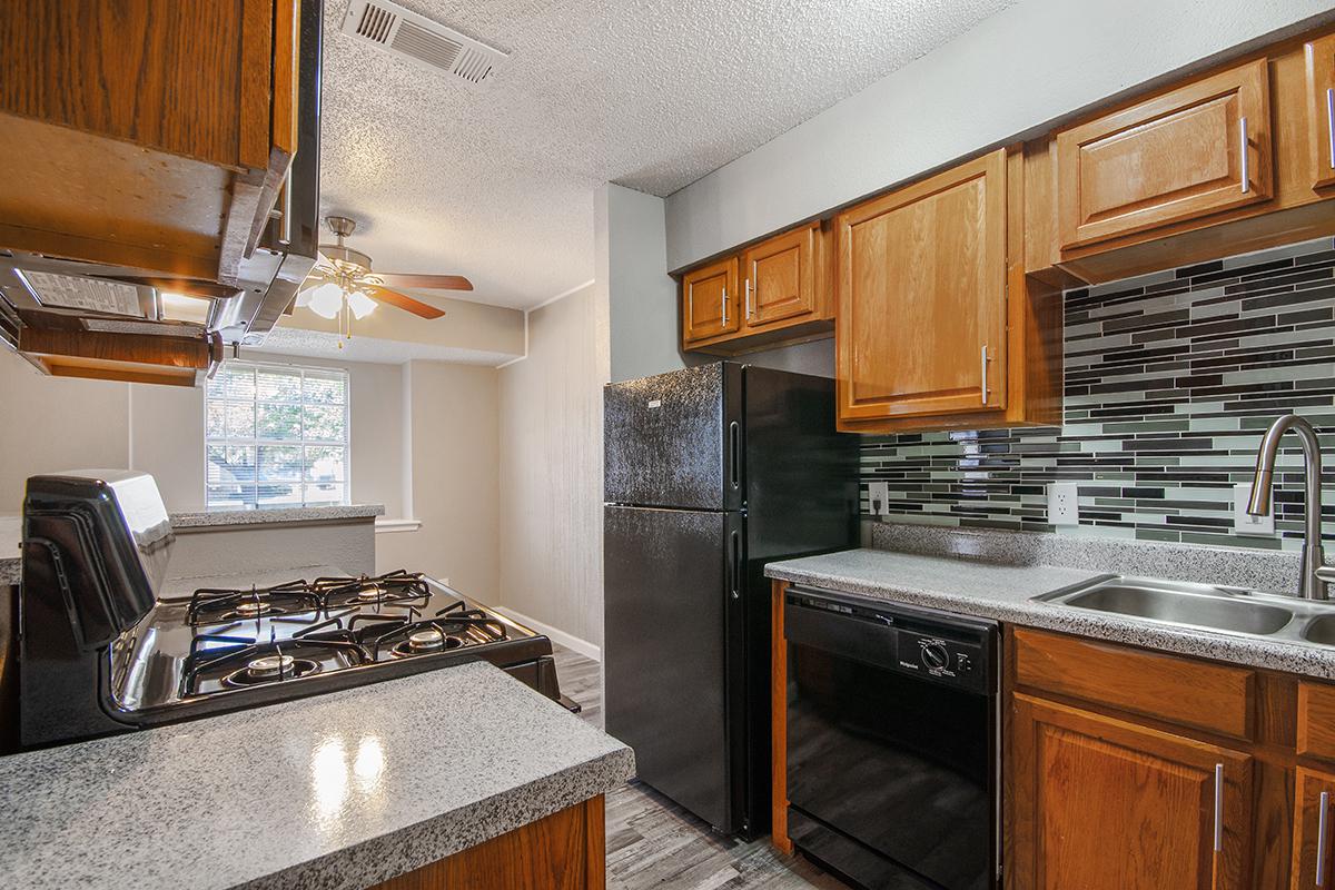 a large kitchen with stainless steel appliances and wooden cabinets