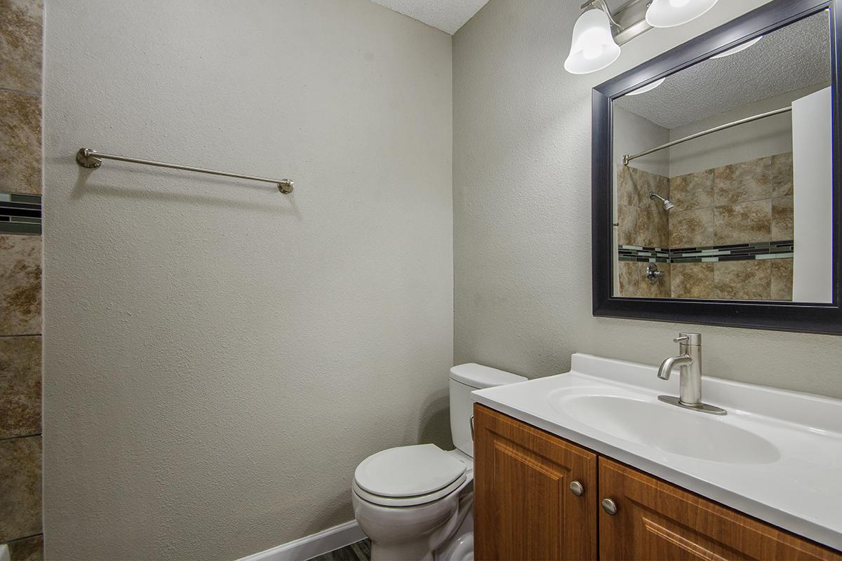 a white sink sitting under a mirror