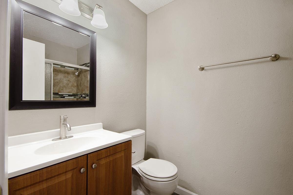 a white sink sitting under a mirror