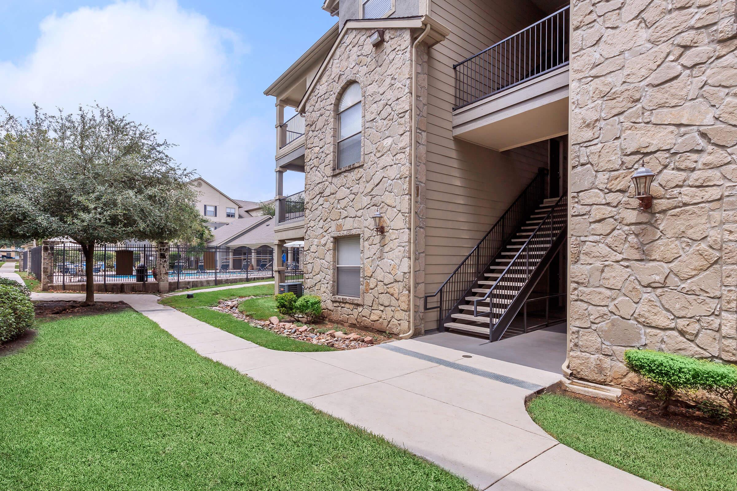 a large lawn in front of a brick building