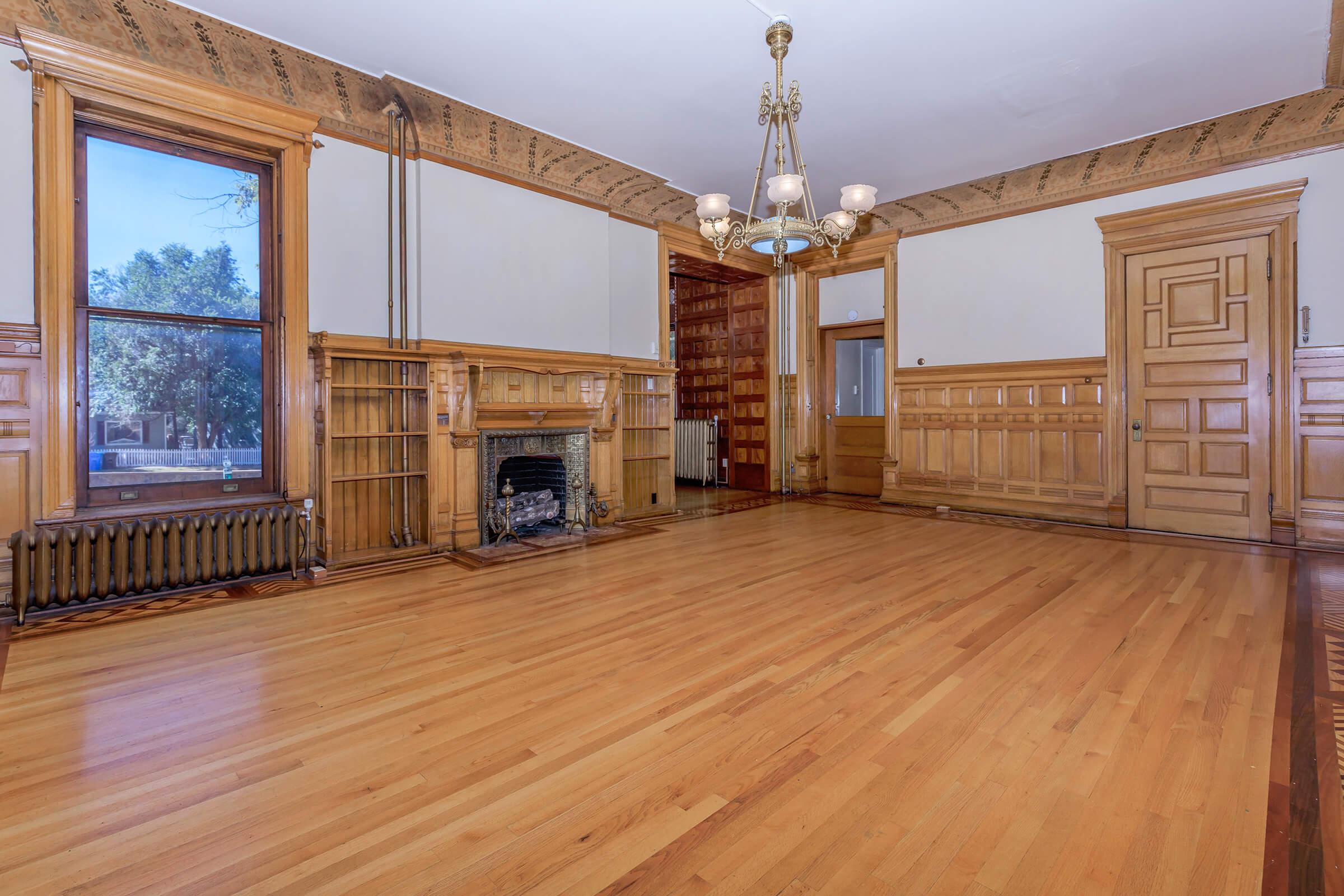 a room with wooden floors and a large window