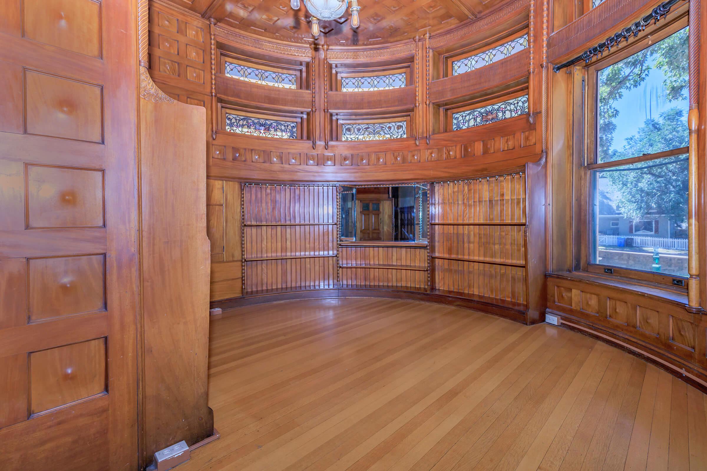 a room with hard wood floors and wooden cabinets
