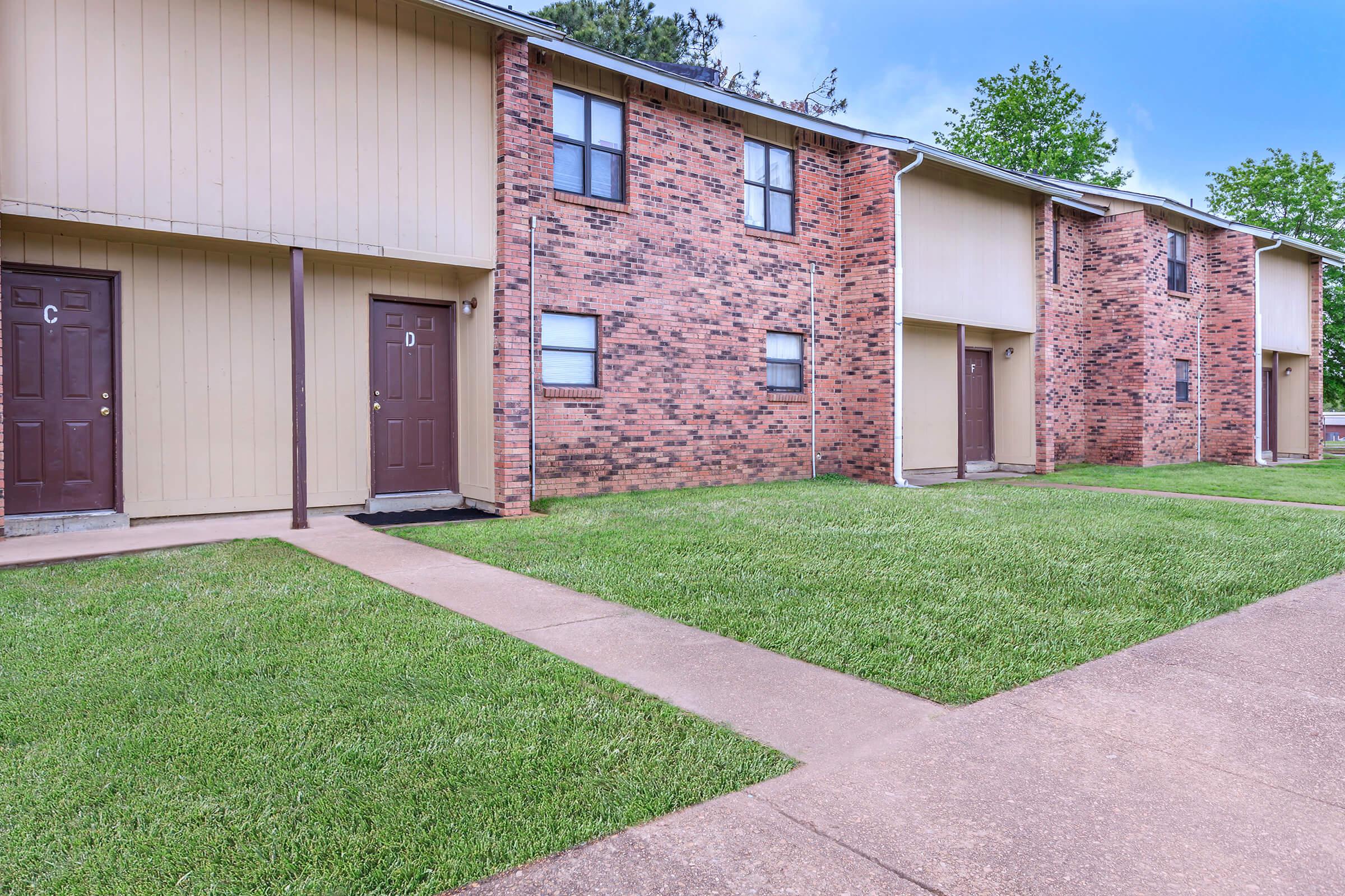 a large lawn in front of a brick building