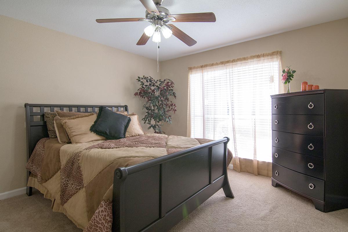 a bedroom with a bed and desk in a room