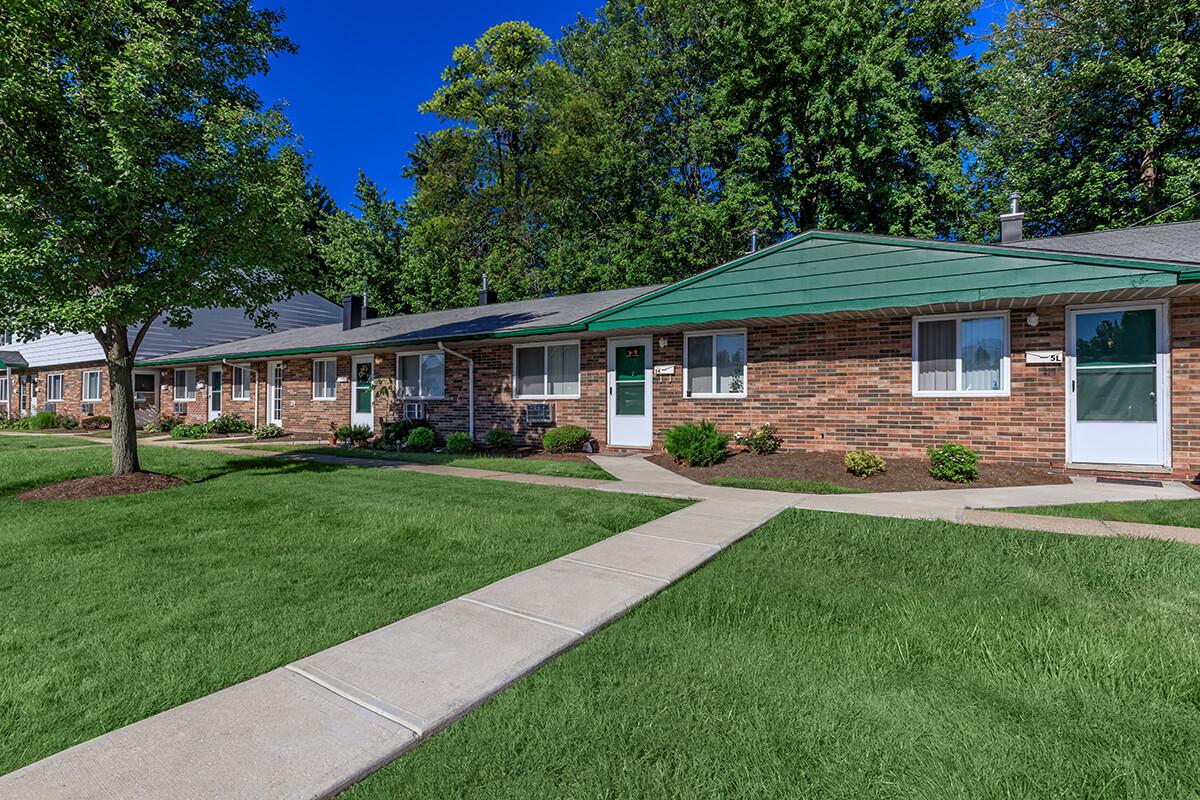 a house with a lawn in front of a brick building