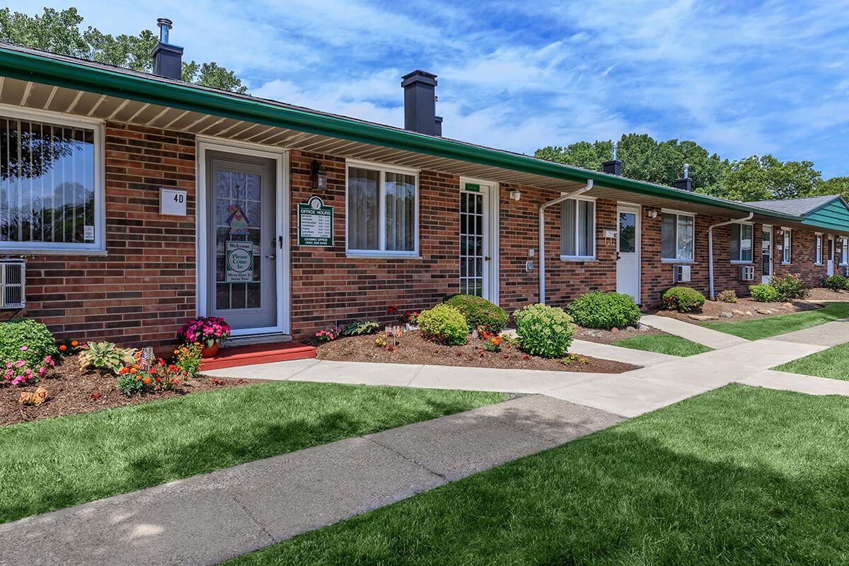 a large brick building with grass in front of a house