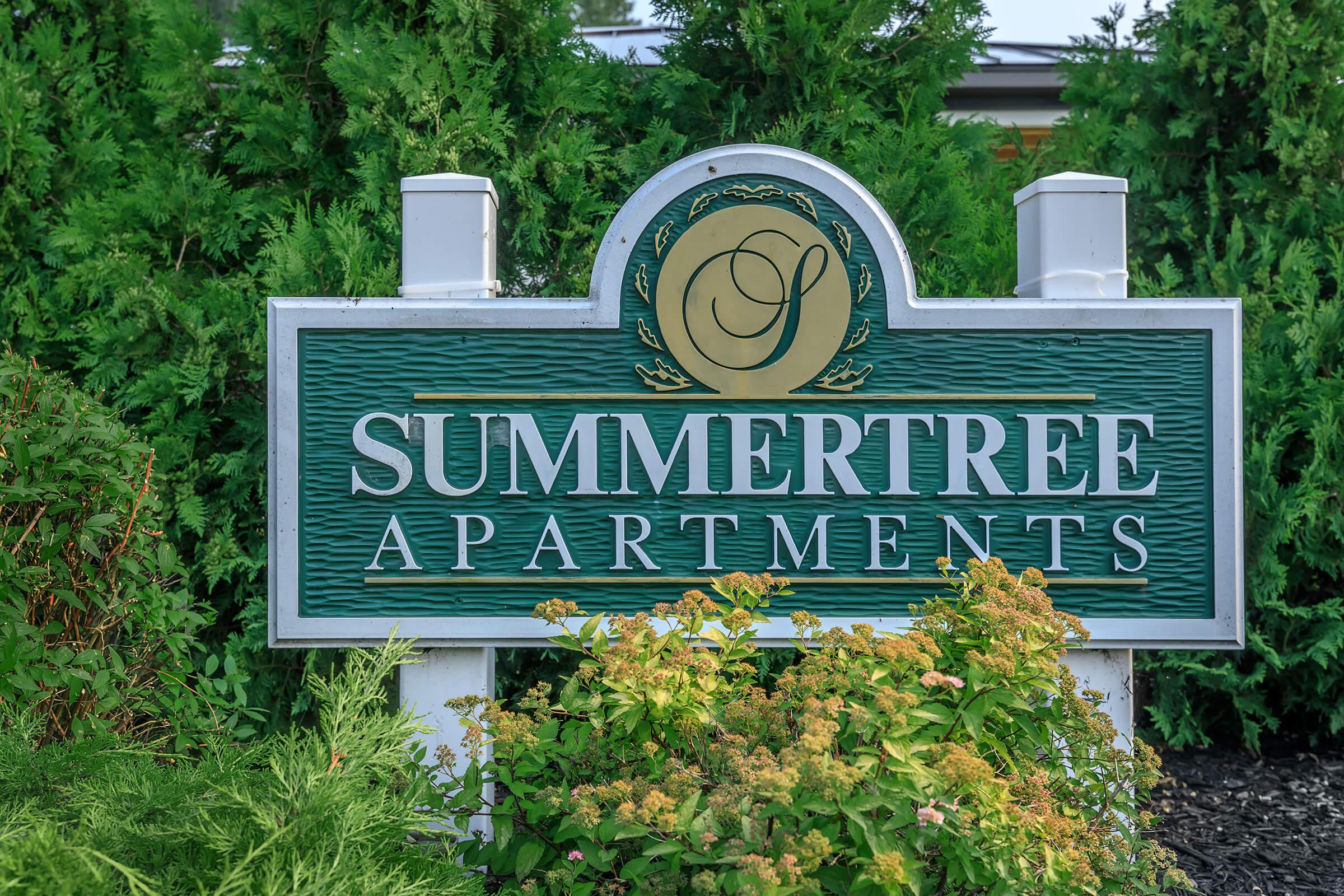 a sign with blue and green bushes