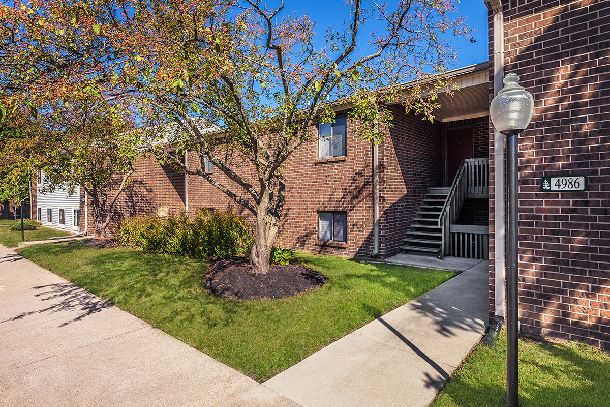 a large brick building with grass in front of a house