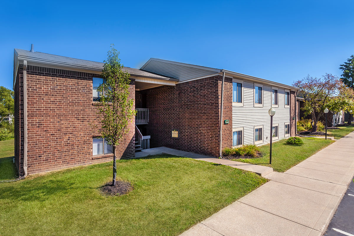 a house with a lawn in front of a brick building